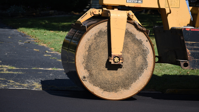 Road roller compacting fresh asphalt