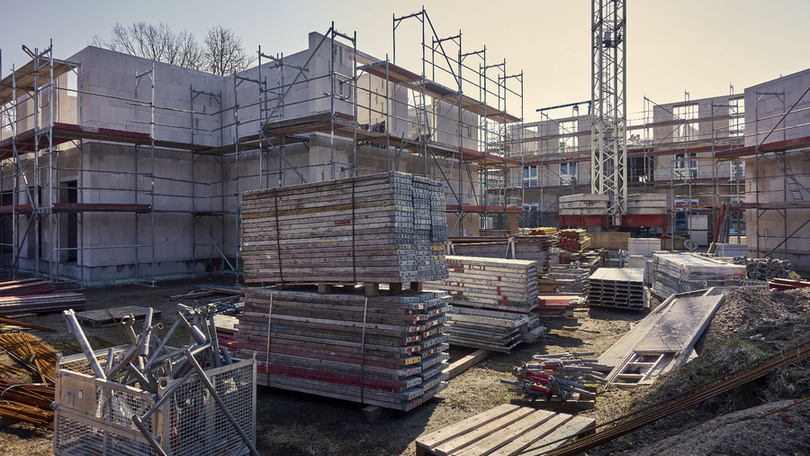 Active construction site with scaffolding and materials